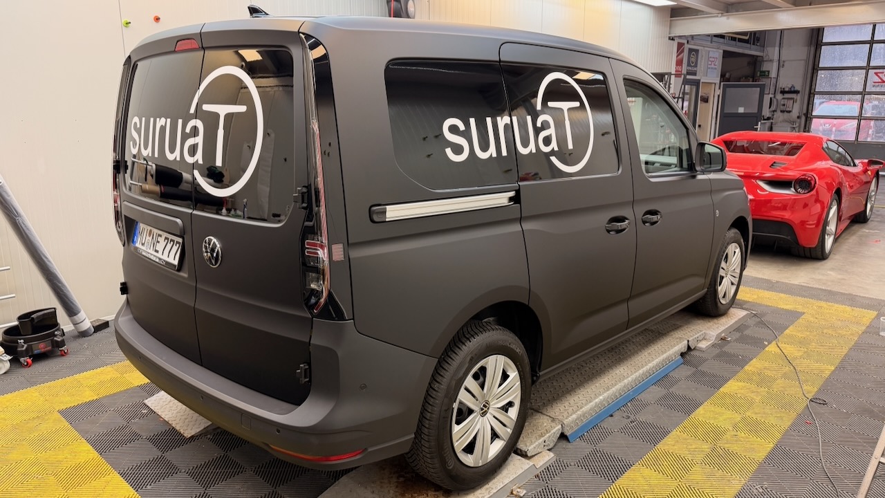 VW Caddy Custom Firmenwagen weiß → Mattschwarz ColorChange PPF Full Wrap mit Suruat-Branding — Royal Glanz München